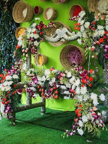 A beautifully decorated swing for a Naming Ceremony. The intricate floral arrangements and colorful backdrop make it a perfect spot for photos.