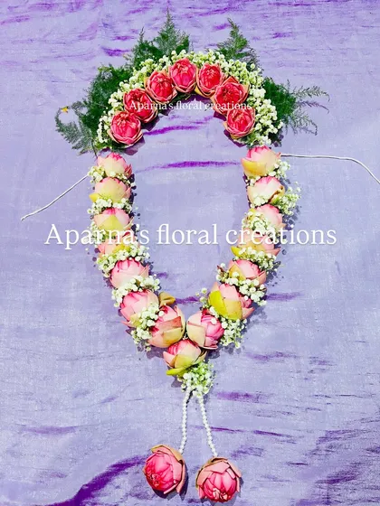 A beautiful garland and veni set made from fresh lotus buds and baby's breath. This is perfect for adorning a deity idol or for a special occasion like a wedding.