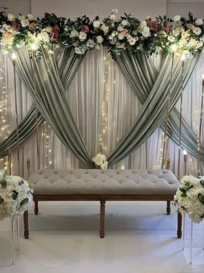 I also create soft and elegant themes for ring ceremonies or intimate weddings. This setup uses beautiful sage green drapes, classic white and pink flowers, and a comfortable tufted bench for a timeless and romantic look.