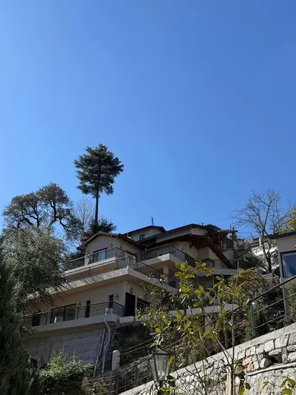 'Soulitude in the Himalayas,' a project nearing completion. The building is terraced into the hillside, with balconies and large windows designed to capture the stunning views of the surrounding mountains.