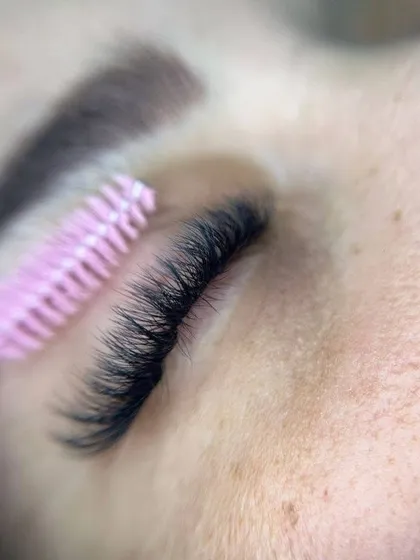 To keep your extensions looking their best, a little daily grooming with a spoolie is all it takes. This shows how soft and flexible the human hair lashes are, allowing them to be brushed into place easily.