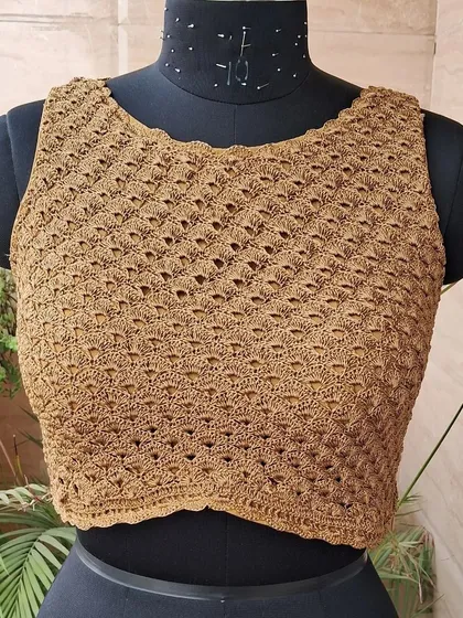 A front view of our popular boat-neck crochet blouse, crafted from rich, earthy-toned yarn. The diagonal stitch pattern adds a unique texture and a flattering fit.