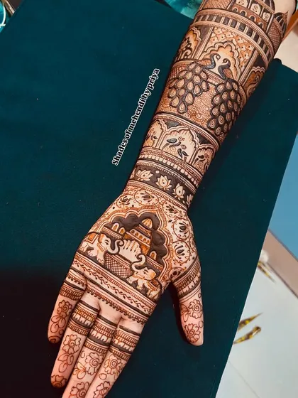 A detailed engagement henna design featuring royal elephants and peacocks. The patterns are dense and intricate, perfect for a grand celebration.
