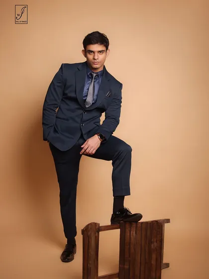 A sharp, formal look for a male model's portfolio. The navy suit and confident pose against a neutral background make for a classic corporate or commercial shot.