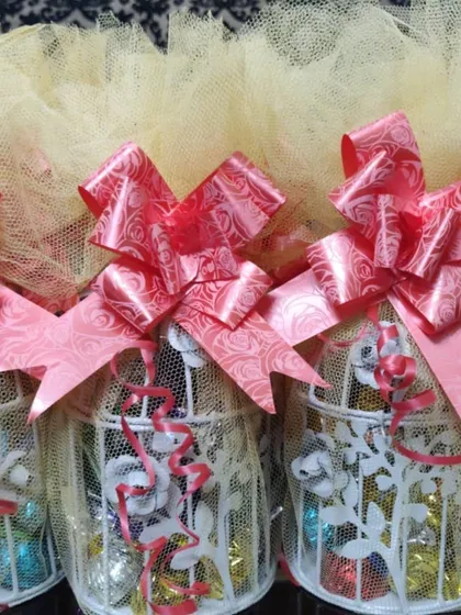 Beautifully decorated return favors featuring mini bird cages filled with assorted chocolates.
