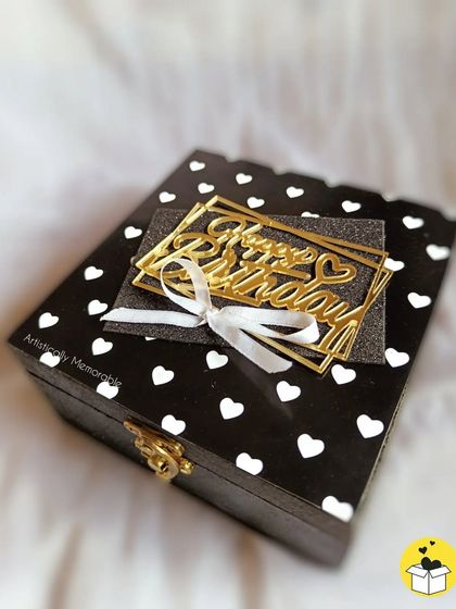 A detailed shot of the mini box hamper, showing the golden clasp and the pretty white bow on the birthday tag.