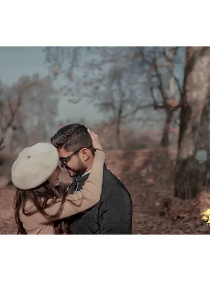 An intimate embrace amidst the beautiful autumn trees of Kashmir. The warm tones and soft light create a cozy and romantic atmosphere.