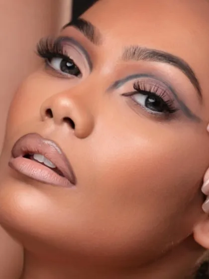 A soft, elegant pose that contrasts with the sharp makeup, creating a balanced image.