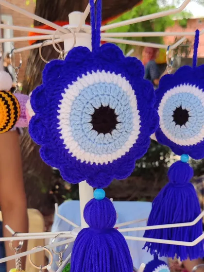A clear, front-on shot of the evil eye wall charm hanging at my stall.