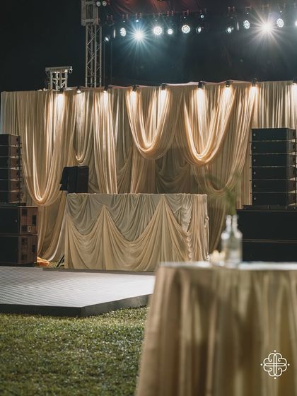 The DJ console and stage for a Goa celebration, draped in elegant, flowing fabrics.