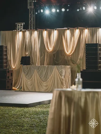 The DJ console and stage for a Goa celebration, draped in elegant, flowing fabrics.