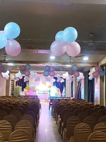 A view of the guest seating area in a hall decorated for a baby shower. We used floating balloon bunches on the ceiling to add color to the entire space.