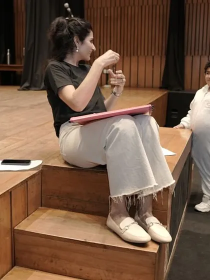 A one-on-one chat with a young actor on the steps of the stage. These quiet moments of mentorship are crucial for building trust and helping a child feel confident and prepared.