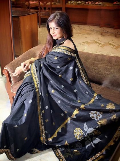 A full-length view of the black handloom saree, showcasing its beautiful drape and traditional motifs.