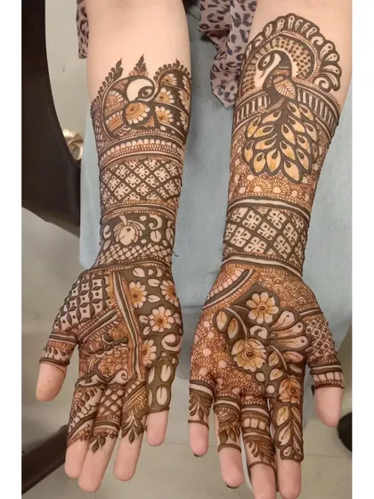 A beautiful combination of peacock motifs on the forearms and delicate floral patterns on the palms and fingers.