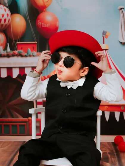 Too cool for two. This little guy is rocking his shades and his second birthday carnival theme with style.