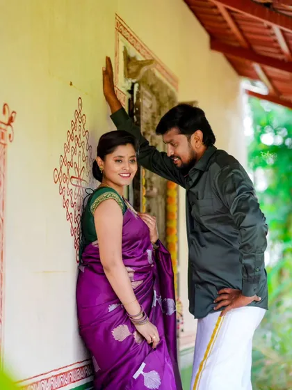 A stylish pose against a wall with traditional Indian paintings. The couple's ethnic wear is perfectly suited for this artistic, cultural backdrop.