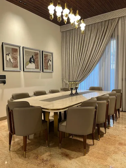 This angle highlights the custom artwork and the elegant sweep of the curtains, which add softness and a personal touch to the formal dining space.