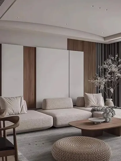 The design of this living space focuses on soft textures and a neutral color palette to create a calming retreat. The modular sofa, plush rug, and delicate cherry blossom branches come together to form a peaceful and elegant interior.