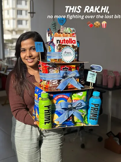 Here I am with our epic Rakhi Food Tower Hamper! I designed this so there’s no more fighting over the last bite. It’s stacked high with all the snacks and chocolates that celebrate the sweet and salty nok-jhok of the sibling bond.