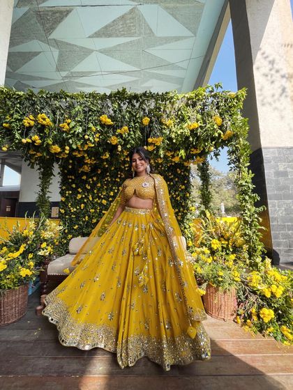 It's raining Haldi. A fun, candid shot of a bride enjoying her Haldi ceremony, with makeup that's fresh, bright, and ready for anything.