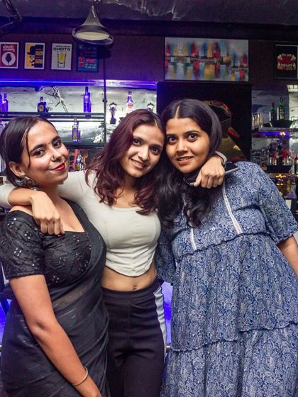 A group of friends enjoying the cool, blue-lit ambiance by the bar.