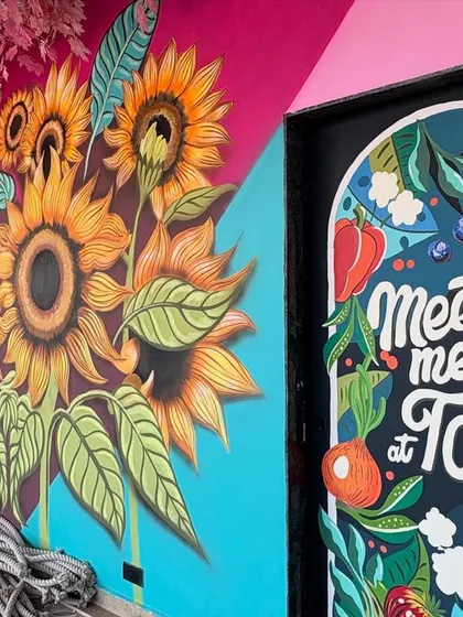 A wider shot showing the kitchen door art next to the large sunflower mural, creating a cohesive and cheerful theme throughout the space.