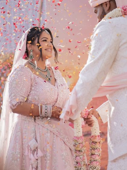 A shower of confetti and joy during the varmala exchange. This image is full of color, energy, and happiness, capturing the peak celebratory moment of the wedding ceremony.
