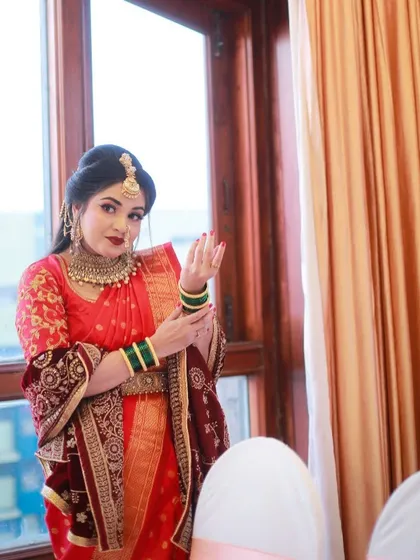 A candid moment captured by the window, showing the bride's thoughtful expression and the beauty of her complete look.