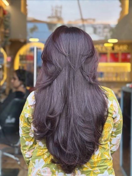 The back view shows how these soft layers are cut to create a beautiful V-shape, which helps in making the hair look fuller and well-styled.