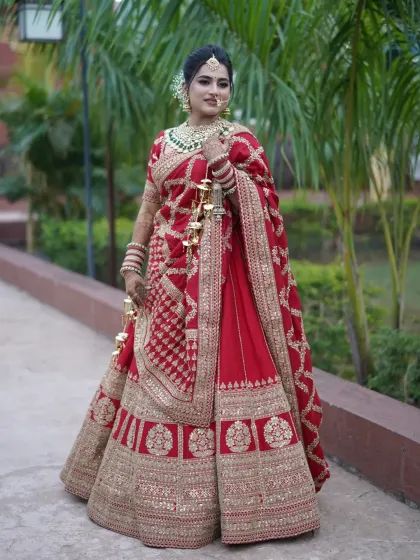 A stunning North Indian bride in a classic red lehenga, looking absolutely regal.