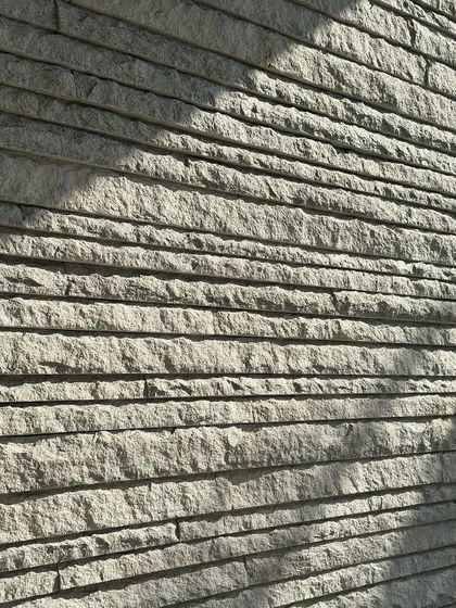 The play of afternoon light and shadow across a textured stone wall.