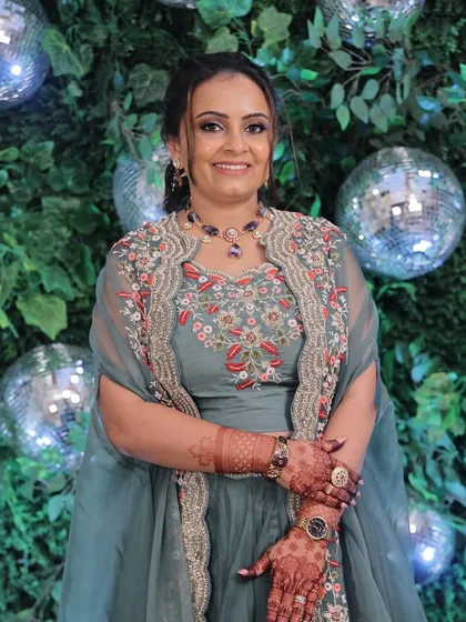 Soft glam with warm coral hues for an engagement party. This look features a defined smokey eye and a simple twisted hairstyle, set against a fun disco ball backdrop.