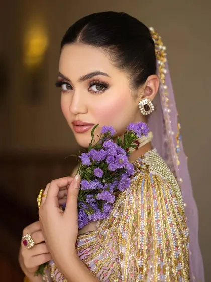 A beautiful portrait showcasing the bride's serene expression and the intricate beadwork on the unique blouse design.