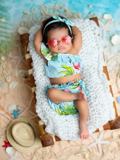 Soaking up the sun in this tropical beach setup. I use real sand, seashells, and miniature beach furniture to create a vacation vibe right in the studio for your little beach baby.