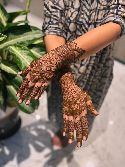 The back of the hands are adorned with dense, circular mandala patterns that are both traditional and visually captivating, perfect for festive occasions.