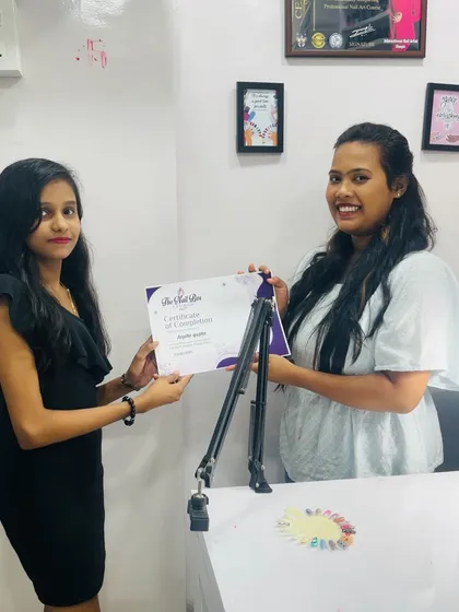 Awarding a certificate to another successful student from the second batch. She is now ready to create beautiful nails for her clients.