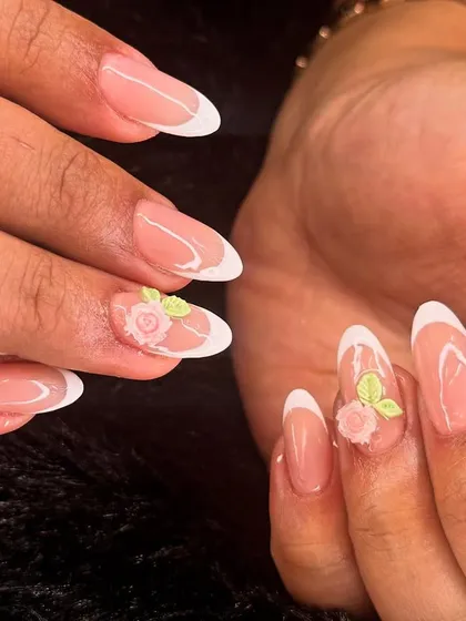 A classic French manicure with a romantic twist. This elegant set features delicate, hand-sculpted 3D roses on the accent nails for a touch of timeless beauty.