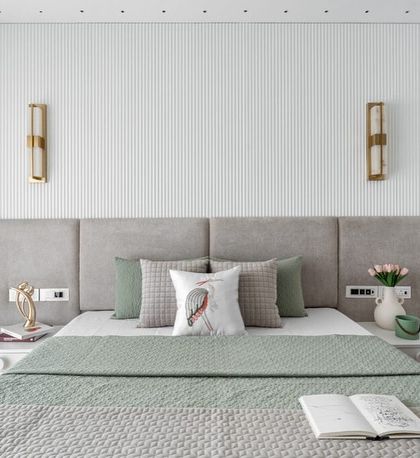 This gorgeous bedroom is all about subtle sophistication. We used sage green tones, a textured grey headboard, and delicate brass wall sconces to create a space that feels calm, modern, and elegant.