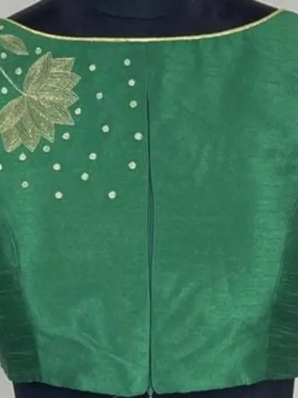A back view of the green hand-embroidered blouse. The clean lines and front-opening design ensure that the beautiful lotus embroidery on the sleeves remains the star of the show.