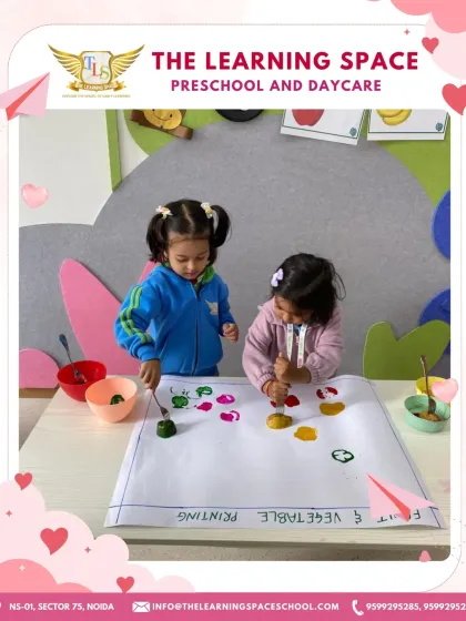 A pair of young artists engaged in vegetable printing. They are learning about cause and effect as they see the beautiful patterns their stamps create.