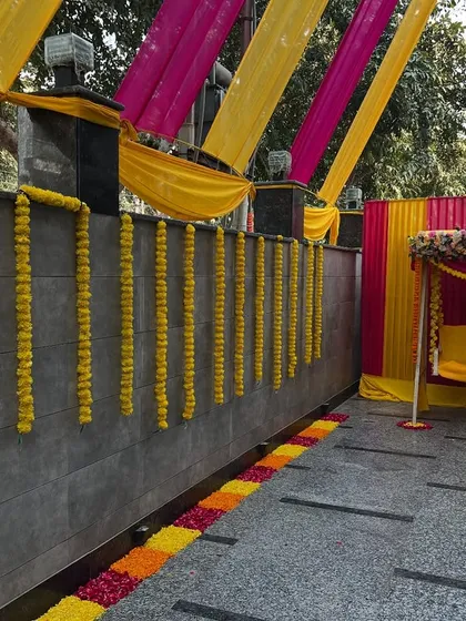 A closer view of the decorated swing and marigold wall hangings, perfect for a daytime mehndi or haldi function at home.