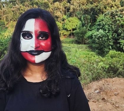 A participant with dramatic red and white face paint, showcasing the artistic side of camp life.