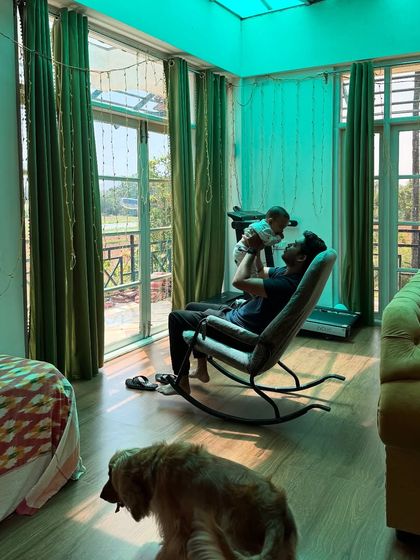 The serene interiors of our room at the farm stay, where my husband is enjoying some playtime with the baby and Posto is relaxing nearby.