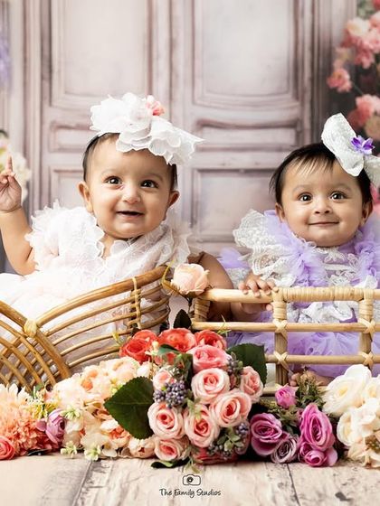 A perfect portrait of the twin baby girls sitting side-by-side, showcasing their budding bond.