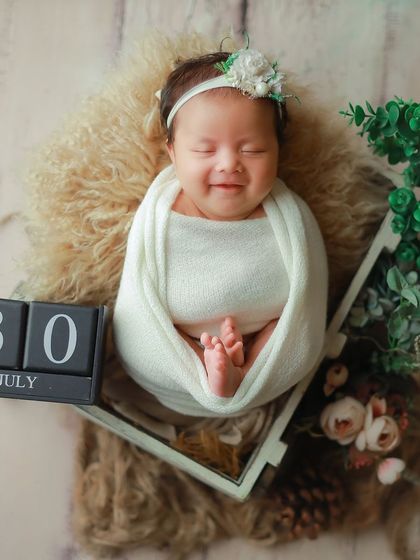 A happy, smiling newborn captured on July 30th. Even when they're not fully asleep, we can capture beautiful, expressive moments.