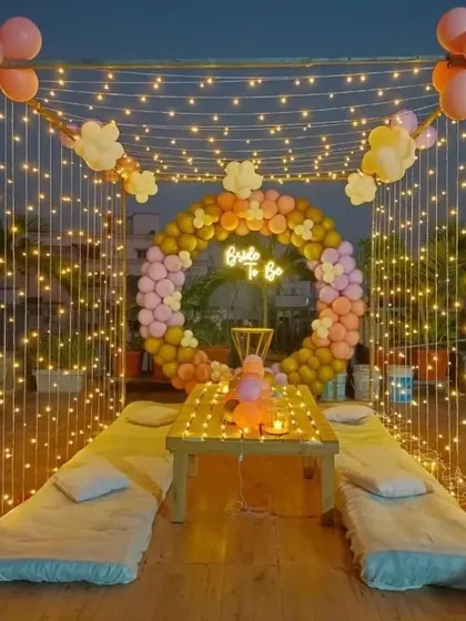 Transforming a simple rooftop into a dreamy 'Bride to Be' celebration space. This setup features a canopy of fairy lights, a custom balloon ring, and comfortable floor seating, creating a magical and intimate atmosphere perfect for a bridal shower under the stars.