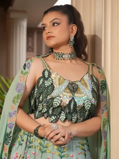 A closer view of the pastel green lehenga, showing the fine embroidery on the cape and the coordinated ring and bracelet.