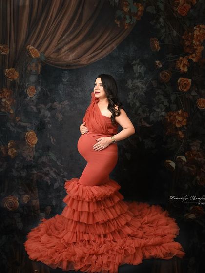 A moody and artistic side profile. The dramatic lighting and the rich texture of the orange gown create a powerful and painterly portrait.