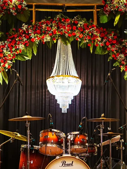 A direct view of the stunning stage backdrop, where a cascade of red flowers and a magnificent chandelier create a luxurious setting for live entertainment.